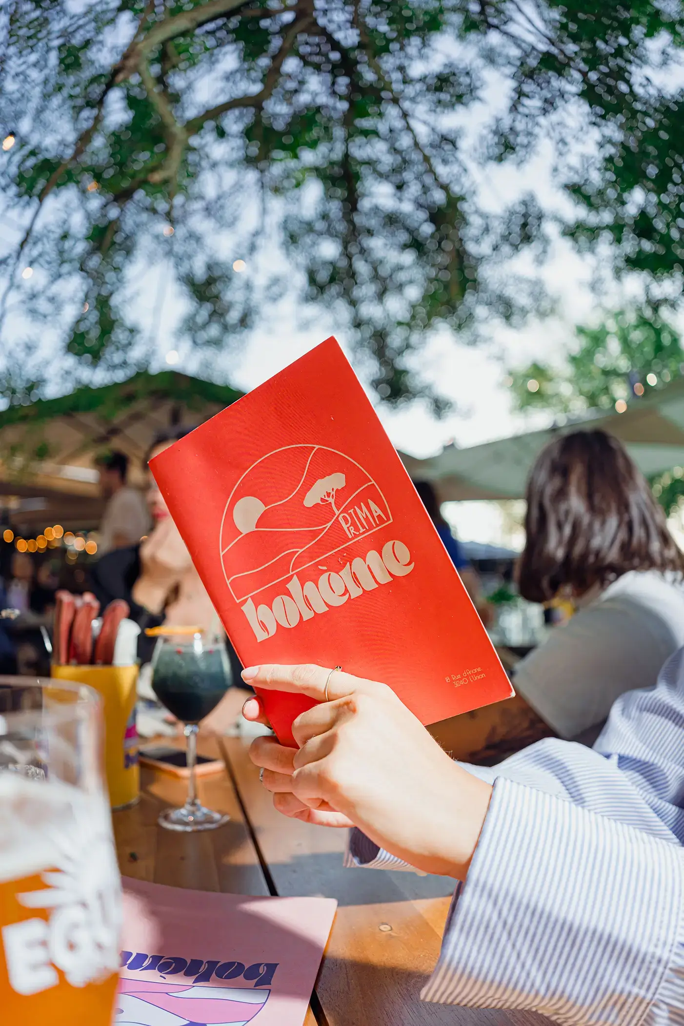 Homme debout sur le bar, une bouteille de Get27 à la main